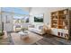 Bright living room featuring a comfy sofa, large windows, and stylish wood floors at 3738 Rosewalk Ct, Highlands Ranch, CO 80129