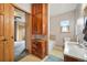 Well-lit bathroom with wooden cabinetry, bathtub, and a window offering natural light and tranquil views at 13080 County Road 19, Platteville, CO 80651