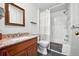 This bathroom features a shower over tub, a granite topped vanity, and a wood framed mirror at 13080 County Road 19, Platteville, CO 80651