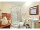 Bathroom featuring a tiled shower, vanity sink, toilet, and a modern glass shower for a spa-like experience at 13080 County Road 19, Platteville, CO 80651
