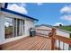 Wood deck with barbecue and sliding glass doors under blue sky at 13080 County Road 19, Platteville, CO 80651