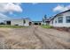 Property featuring a large driveway, multiple garages, well-kept lawn, and a charming two-story white and blue home at 13080 County Road 19, Platteville, CO 80651