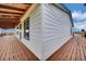 Corner view of white home with wood deck and blue trim at 13080 County Road 19, Platteville, CO 80651