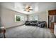 Open living room with large window, plush carpet, and convenient access to the kitchen and stainless steel refrigerator at 13080 County Road 19, Platteville, CO 80651
