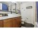 Bathroom featuring wooden vanity, vessel sink, dark slate floors, toilet, and shower with blue curtain at 3379 Cranston Cir, Littleton, CO 80126