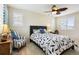 A bedroom with a ceiling fan, large windows, and a chair in the corner at 3379 Cranston Cir, Littleton, CO 80126