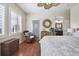 This bedroom features wood floors, a ceiling fan, and a view to the ensuite bathroom at 3379 Cranston Cir, Littleton, CO 80126