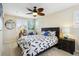 A bedroom with a ceiling fan, large windows, and a leafy comforter on the bed at 3379 Cranston Cir, Littleton, CO 80126