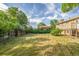 Large, grassy backyard with mature trees and a partial view of the house and deck at 12883 E Nevada Cir, Aurora, CO 80012
