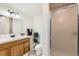 Well-lit bathroom featuring a vanity with a sink, a toilet, and a glass-enclosed shower, providing essential amenities at 270 Terra Vista St, Brighton, CO 80601