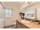 Bright bathroom with tan vanity, beige tile counters and floors and combined laundry area at 270 Terra Vista St, Brighton, CO 80601