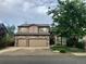 Two-story home with stone accents, a two-car garage, well-manicured lawn, and mature shade trees at 270 Terra Vista St, Brighton, CO 80601