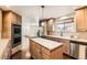 Functional kitchen featuring an island, stainless steel appliances and hardwood floors at 270 Terra Vista St, Brighton, CO 80601