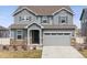 Charming two-story home features a two-car garage, gray siding, stone accents, and matching gray shutters at 6243 Saddle Bow Ave, Parker, CO 80134
