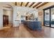 Open kitchen with large island, exposed beams, and stainless steel appliances at 10010 Steeplechase Dr, Franktown, CO 80116