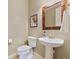 Powder room with pedestal sink, decorative mirror, tile floors, and natural colored walls at 775 Woodgate Dr, Highlands Ranch, CO 80126