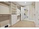 Walk-in closet with custom shelving and storage, with plush carpeting throughout at 775 Woodgate Dr, Highlands Ranch, CO 80126