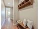 Hallway with hardwood floors, decorated with wood shelf, hooks, pillows and decor at 775 Woodgate Dr, Highlands Ranch, CO 80126