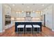 Bright kitchen with white cabinets, stainless steel appliances, and a large island with seating at 775 Woodgate Dr, Highlands Ranch, CO 80126
