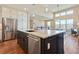 A kitchen island with a sink, granite countertops, stainless steel appliances, and hardwood flooring at 775 Woodgate Dr, Highlands Ranch, CO 80126
