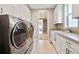 Large laundry room with modern washer and dryer, with storage and folding counter space at 775 Woodgate Dr, Highlands Ranch, CO 80126