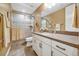 Well-lit bathroom with double vanity, quartz counters, a modern faucet, framed mirror and a glass enclosed shower at 775 Woodgate Dr, Littleton, CO 80126