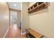 Hallway with hardwood floors and rustic wood bench and shelf at 775 Woodgate Dr, Littleton, CO 80126