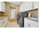 Well-equipped laundry room with gray washer and dryer, and white storage cabinets at 775 Woodgate Dr, Littleton, CO 80126