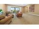 Comfortable seating arrangements adorn the carpeted living room, featuring sliding doors to the outside patio and a decorative quilt at 775 Woodgate Dr, Littleton, CO 80126