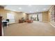 Spacious carpeted living room with recessed lights, a large window, and a sliding glass door to the outside patio at 775 Woodgate Dr, Littleton, CO 80126