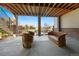 Under deck patio with view of the backyard and neighborhood featuring wood-look chairs and a sofa at 775 Woodgate Dr, Littleton, CO 80126