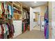 Large walk-in closet with custom shelving and storage, adjacent to the laundry room at 775 Woodgate Dr, Littleton, CO 80126