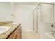 Bathroom with granite counter, double sinks, and a glass shower and bath combo at 1950 N Logan St # 102, Denver, CO 80203