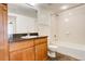 Spacious bathroom with a granite counter, wood cabinets, and bath/shower combo at 1950 N Logan St # 102, Denver, CO 80203