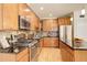 Well-equipped kitchen with stainless steel appliances, dark countertops, and warm wood cabinetry at 1950 N Logan St # 102, Denver, CO 80203