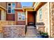 This home's entrance features a decorative brick wall and a cozy front porch area at 9581 Firenze Way, Highlands Ranch, CO 80126