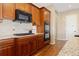 This kitchen features wooden cabinets, a granite countertop, and stainless steel appliances at 9581 Firenze Way, Highlands Ranch, CO 80126