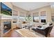 Comfortable living room featuring a brick fireplace, large windows, and stylish furniture at 9581 Firenze Way, Highlands Ranch, CO 80126