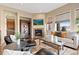 Inviting living room boasts a fireplace, stylish furniture, and natural light from large windows at 9581 Firenze Way, Highlands Ranch, CO 80126