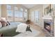Inviting main bedroom with a fireplace, french doors, and ample natural light at 9581 Firenze Way, Highlands Ranch, CO 80126