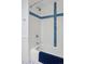 Bathroom featuring a tiled shower and tub with blue accents at 4967 E Lake Ave, Centennial, CO 80121
