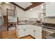 Open kitchen featuring granite countertops, white cabinets, stainless steel appliances, and view of staircase and living space at 4967 E Lake Ave, Centennial, CO 80121