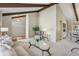 Spacious living room showcasing vaulted ceilings with exposed beams, and open layout connecting to dining area at 4967 E Lake Ave, Centennial, CO 80121