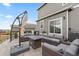 Stylish back patio featuring comfortable seating, a modern fire pit, and an umbrella at 14075 Scarlet Sage St, Parker, CO 80134