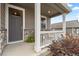 Inviting front porch with white railings, stone accents, and a cozy seating area at 14075 Scarlet Sage St, Parker, CO 80134
