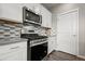 Kitchen featuring stainless steel oven, microwave, and modern backsplash at 14075 Scarlet Sage St, Parker, CO 80134