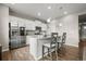 Modern kitchen with stainless steel appliances, white cabinets, and a center island with bar stool seating at 14075 Scarlet Sage St, Parker, CO 80134