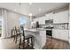 Modern kitchen featuring white cabinets, stainless steel appliances, and a spacious island with barstool seating at 14075 Scarlet Sage St, Parker, CO 80134