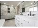Bright bathroom featuring walk-in shower with marble tile, and a double vanity with modern fixtures at 11383 W 28Th Ave, Lakewood, CO 80215