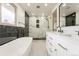 Elegant bathroom featuring a soaking tub, walk-in shower with marble tile, and a double vanity with modern fixtures at 11383 W 28Th Ave, Lakewood, CO 80215
